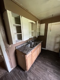 an empty kitchen with cabinets and a sink